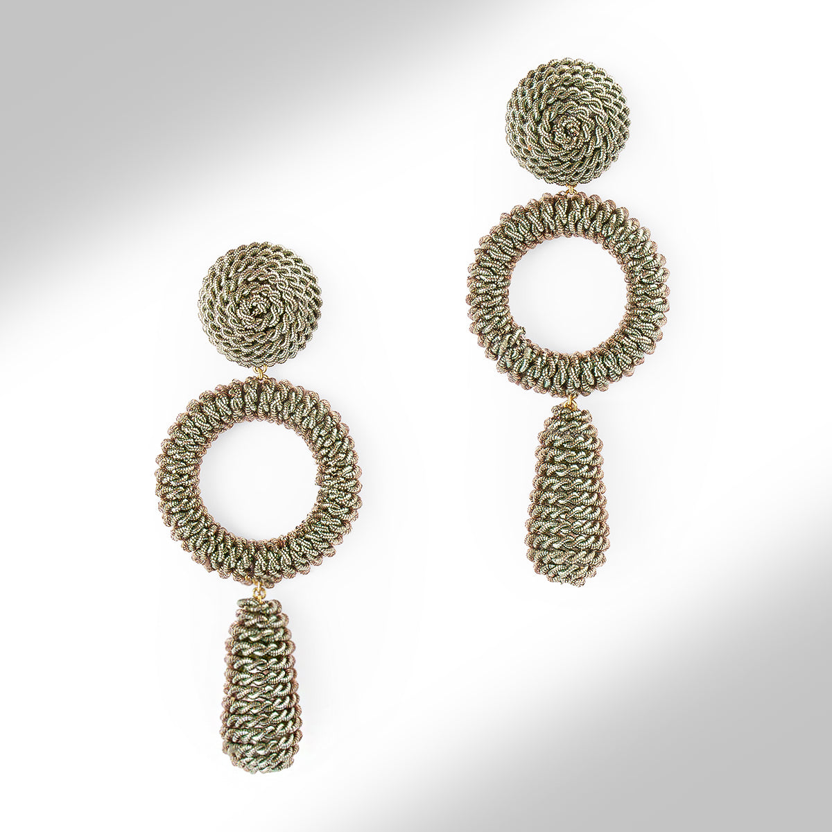 A pair of textured, multi-layered dangle earrings in a metallic finish on a light gray gradient background.