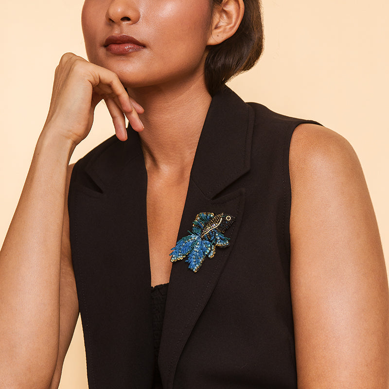 Model wearing Deepa Gurnani handmade Guppy brooch in blue color