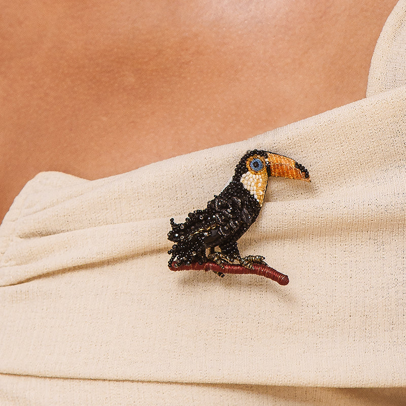 Model wearing Deepa Gurnani handmade Toucan brooch in black color.