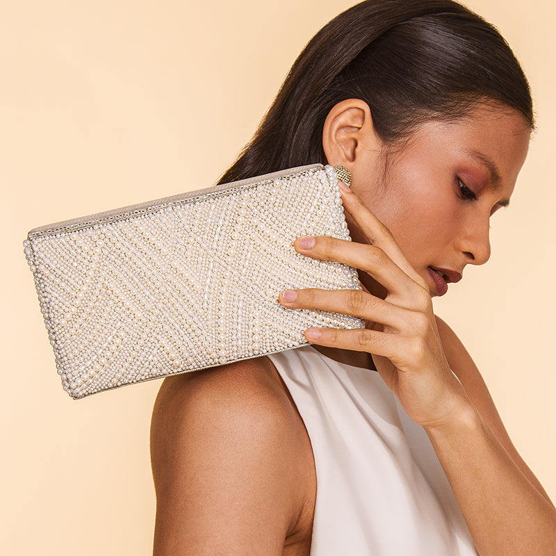 Model Carrying Deepa Gurnani Handmade Logan clutch in Ivory color