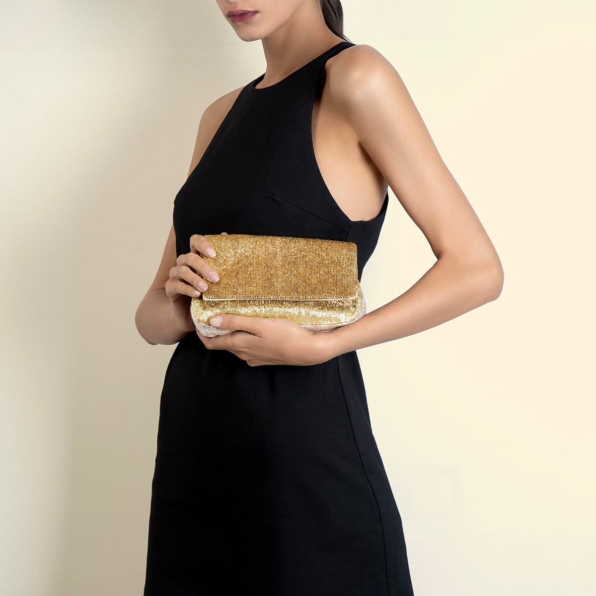 Model carrying Deepa Gurnani gold Luann Clutch