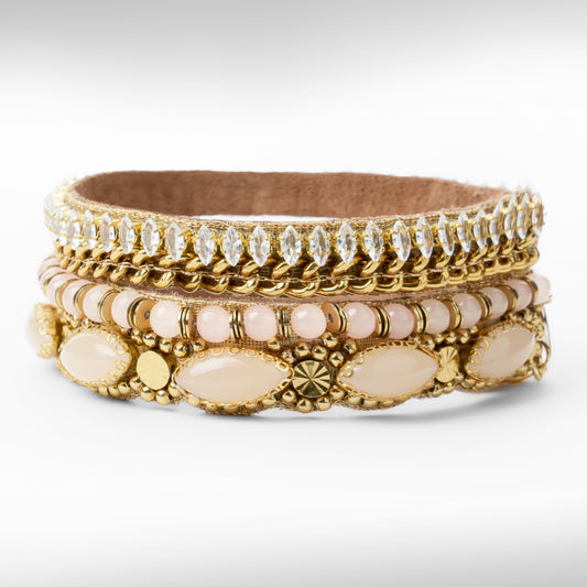 A gold-toned beaded and rhinestone bracelet with pale pink beads and oval stone accents, photographed on a clean white background.