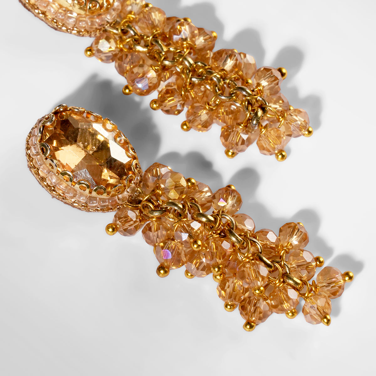 Close up of Deepa Gurnani Jemsa Earrings in champagne color