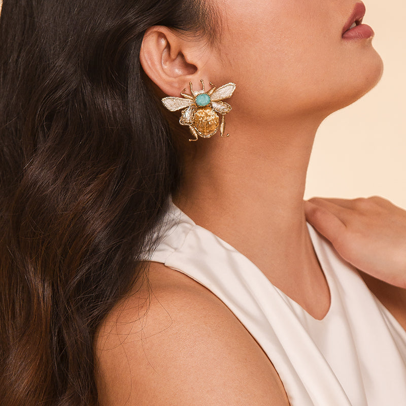 Detail of Model wearing Deepa Gurnani handmade the Scarab earring in gold color