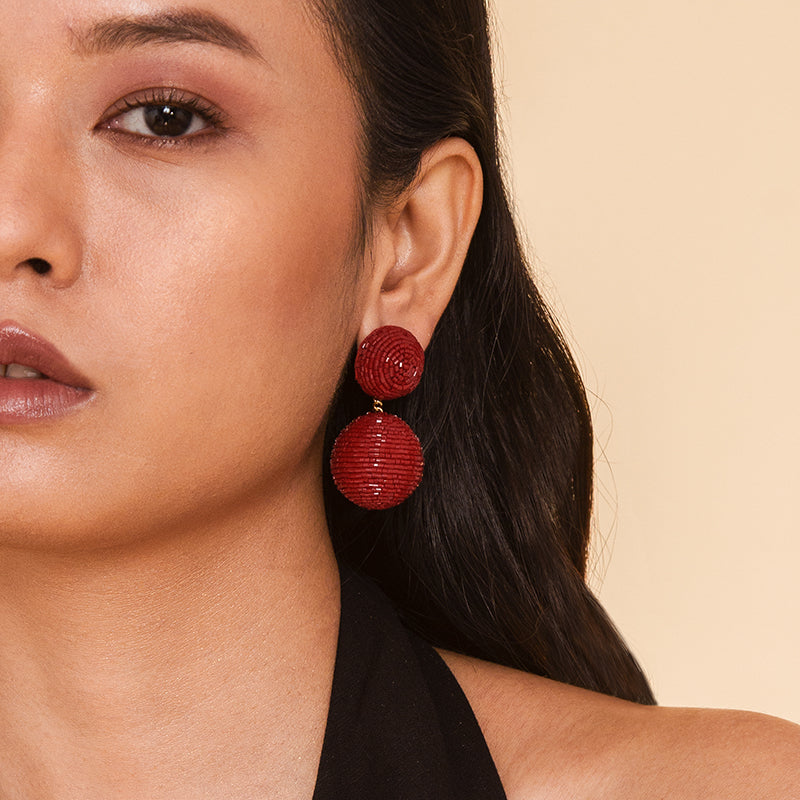 Detail of model wearing our Deepa Gurnani handmade the Nica earring in Maroon color