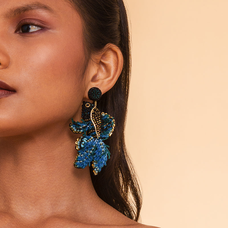 Model wearing  Deepa Gurnani handmade the Guppy earrings in blue color.