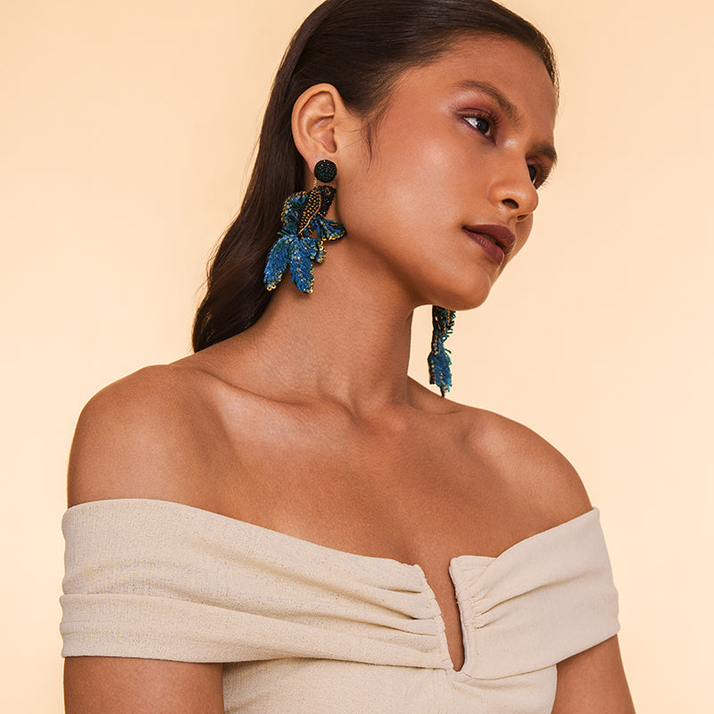 Model wearing  Deepa Gurnani handmade the Guppy earrings in blue color.