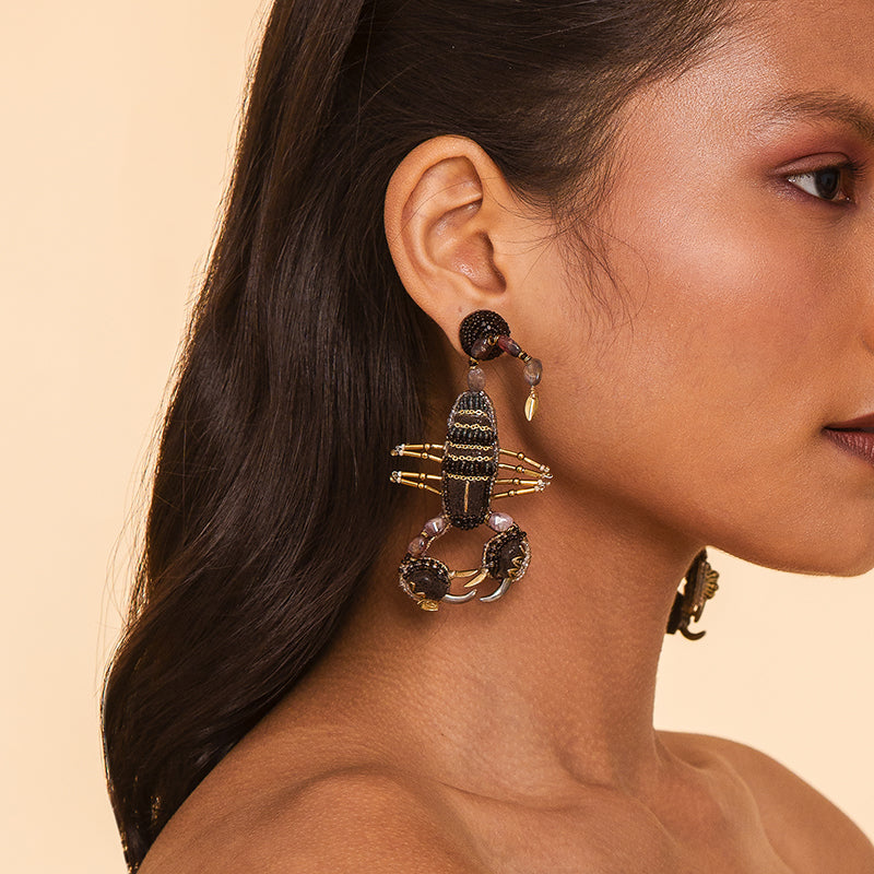 Model wearing Deepa Gurnani handmade the Scorpion earrings in Brown color.