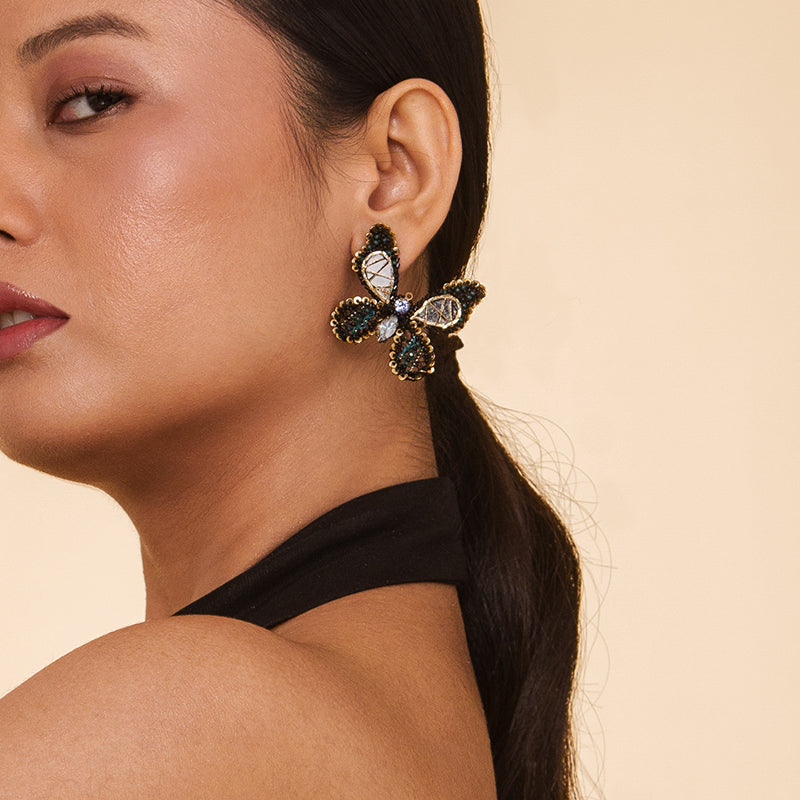 Detail of model wearing Deepa Gurnani Handmade Renesmee Earrings in Emerald color