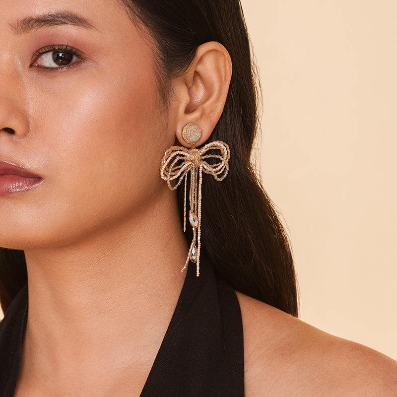 Detail of Model wearing Deepa Gurnani Handmade Coquette Earrings in Champagne