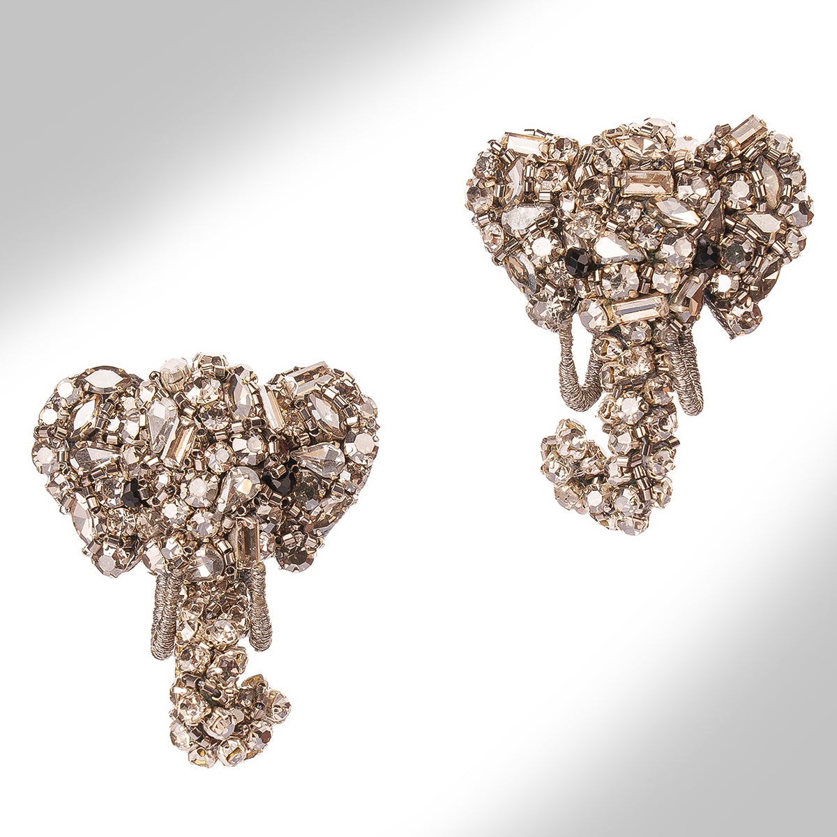 A pair of ornate elephant-shaped earrings shown on a white background.