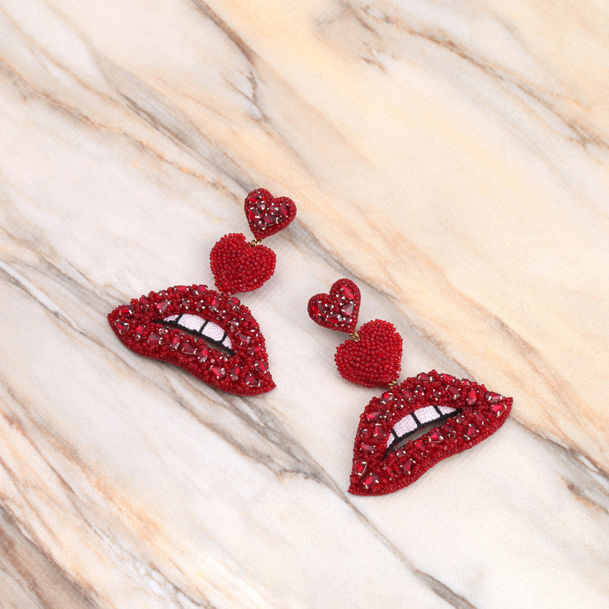 Handmade Luscious crystal red lip earrings on marble background